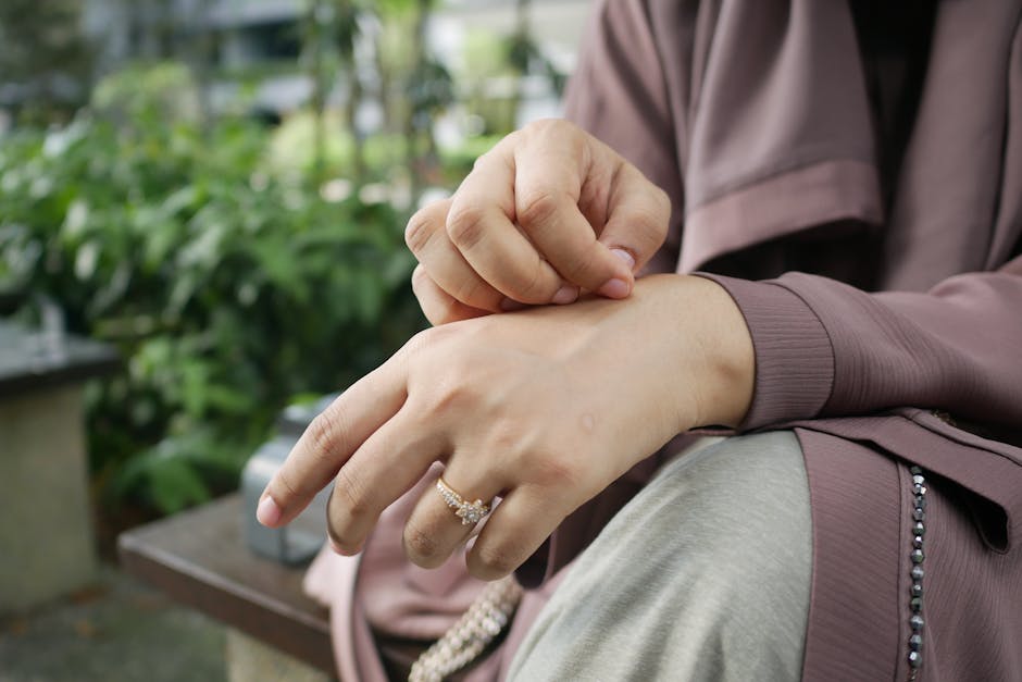 Close-up of hands with a beautiful ring in an outdoor setting, showcasing elegance.