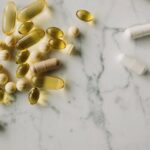A variety of capsules and pills scattered on a marble surface, offering a modern healthcare concept.